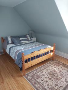 a bed with a wooden frame in a bedroom at 2 bedroom apartment in historical home in Barrie