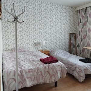 a bedroom with a bed and a cross on the wall at Scandinavian taiteilijan 3h huoneisto in Lahti