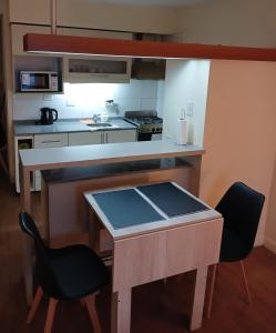 eine kleine Küche mit einem Tisch und 2 Stühlen in der Unterkunft Terra1 in San Carlos de Bariloche