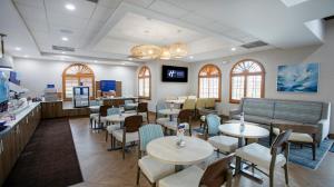 a restaurant with tables and chairs and a counter at Holiday Inn Express- North Palm Beach and IHG Hotel in Juno Beach