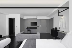 a black and white room with a bed and a couch at Hotel Mono in Singapore