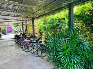 una fila de bicicletas estacionadas bajo un edificio en Koh Jum Bungalow & Hostel, en Ko Jum