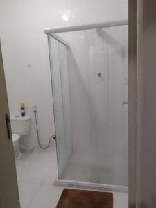 uma cabina de duche em vidro numa casa de banho com WC em APT Praia Forte Passagem em Cabo Frio