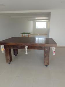 uma mesa de madeira em cima de um quarto em APT Praia Forte Passagem em Cabo Frio