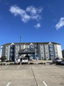 a large building with a parking lot in front of it at Microtel Inn and Suites Baton Rouge Airport in Baton Rouge