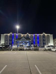 a parking lot in front of a building with blue lights at Microtel Inn and Suites Baton Rouge Airport in Baton Rouge