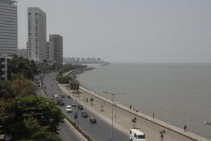 a busy city street with cars on a road next to the water at Sea Green South Hotel in Mumbai