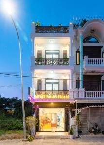 Nhat Minh Hotel Dalat في دالات: مبنى ابيض كبير عليه لافته