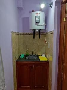 una cocina con fregadero y un cubo en la pared en La Norteña Tres Cerritos en Salta