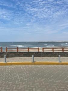 eine Bank am Strand mit dem Meer im Hintergrund in der Unterkunft Casa de mamá María in Malabrigo