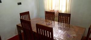 阿努拉德普勒的住宿－Bingu Villa，餐桌、四把椅子和一张木桌
