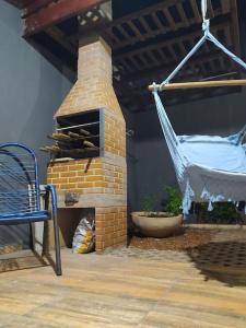 eine Hängematte auf einer Terrasse mit einem gemauerten Kamin in der Unterkunft Casa 3min do centro prox. UFMS in Campo Grande