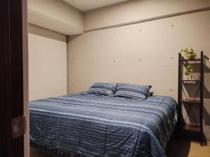 ein Bett mit zwei blauen Kissen in einem Zimmer in der Unterkunft Residencial Chicle D401 in Mexiko-Stadt