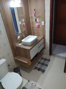 ein Badezimmer mit einem weißen WC und einem Waschbecken in der Unterkunft Casa 3min do centro prox. UFMS in Campo Grande