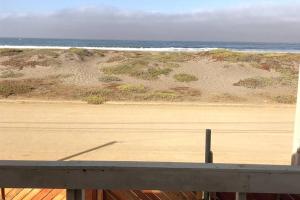 uma vista para uma praia com o oceano e um corrimão de madeira em Casa, acceso directo a Playas Blancas, Las cruces 2 noches minimo em Las Cruces