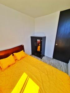 a bedroom with a large yellow bed with a fireplace at Apartamento compartido en dosquebradas in Dosquebradas
