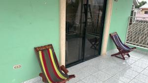 two chairs sitting on the front porch of a house at Vacation Home La Ceiba in La Ceiba