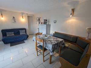 SercoeurにあるGîte ensoleillé idéal pour couples - Proche d'Épinal avec terrasse et Wifi - FR-1-589-613のテーブルとソファのあるリビングルーム