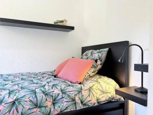 uma cama com uma almofada cor-de-rosa em cima em Appartement Bormes-les-Mimosas, 3 pièces, 5 personnes - FR-1-251-575 em Bormes-les-Mimosas