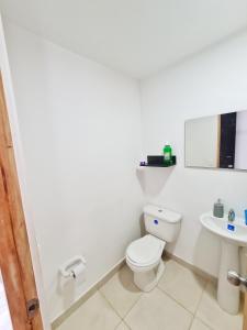 a white bathroom with a toilet and a sink at Apartamento compartido en dosquebradas in Dosquebradas