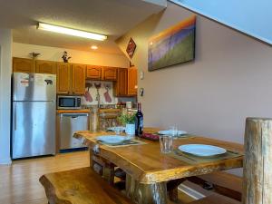 a kitchen with a wooden table and a refrigerator at Heavenly View - Bear Themed Cabin, HotTub, Dog-Friendly, Near Gatlinburg in Gatlinburg