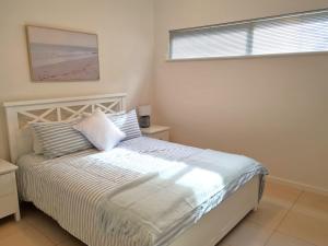 a bedroom with a white bed with a window at Number 99B in Pine Point