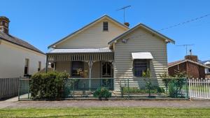 a house with a fence in front of it at Learmonth Guesthouse - Queenscliff in Queenscliff