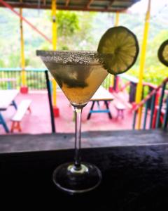 ein Getränk auf einem Tisch mit einem Stück Limette in der Unterkunft CARIBbEAN Paradise Hotel in Lanquín