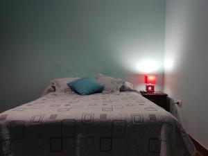 Un dormitorio con una cama con una almohada azul. en La Norteña tres cerritos 2 en Salta