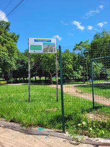 een hek met een bord in het gras bij Casa espaçosa com linda piscina in Porto Velho