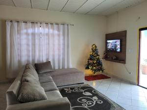 uma sala de estar com um sofá e uma árvore de Natal em Casa espaçosa com linda piscina em Porto Velho