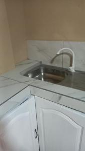 a kitchen counter with a sink with a faucet at Liz One Stop Apartment in Georgetown