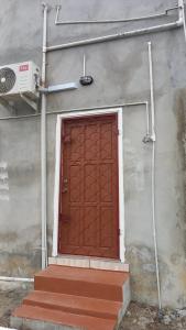 a red door on the side of a building at Liz One Stop Apartment in Georgetown