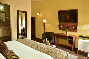 a hotel room with a bed and a flat screen tv at Casa de Avila in Arequipa