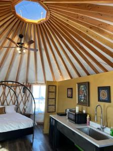 cocina con techo con fregadero y cama en The Lotus Yurt at Nomad Yurts, Lake Powell, en Big Water