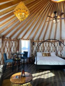 1 dormitorio en una yurta con cama y mesa en The Lotus Yurt at Nomad Yurts, Lake Powell, en Big Water