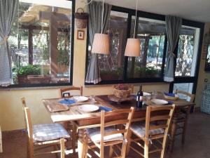 comedor con mesa, sillas y ventanas en Casa Vacanze I Piani, en Olmedo