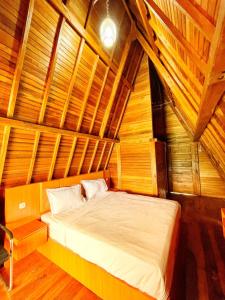 um quarto com uma cama num quarto de madeira em ANARA VILLA SAMOSIR MANAGED BY 3 SMART HOTEL em Sinapuran