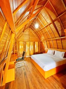ein Schlafzimmer mit einem Bett in einer Holzdecke in der Unterkunft ANARA VILLA SAMOSIR MANAGED BY 3 SMART HOTEL in Sinapuran