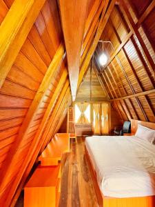 a bedroom with a bed in a wooden ceiling at ANARA VILLA SAMOSIR MANAGED BY 3 SMART HOTEL in Sinapuran