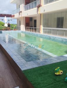 une piscine en face d'un bâtiment dans l'établissement Apartamento no Atalaia, à Salinópolis