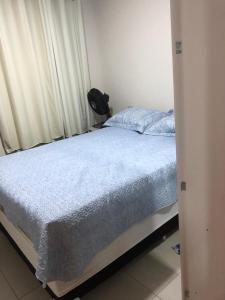 - une chambre avec un lit et une couverture bleue dans l'établissement Apartamento no Atalaia, à Salinópolis