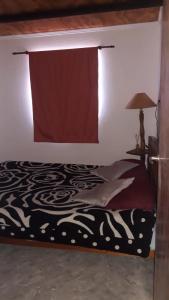1 dormitorio con 1 cama con cortina roja en Estadía temporal en Quebrada de los Códores