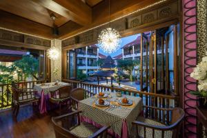 a balcony with tables and chairs and a chandelier at Puripunn Hideaway in Chiang Mai