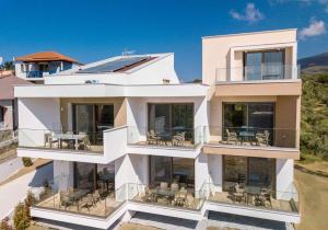 Casa blanca con balcones y mesas en Aria suites, en Limenaria