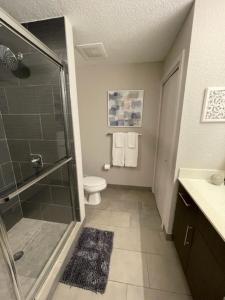 uma casa de banho com um chuveiro, um WC e um lavatório. em Stylish Modern 3bd-2ba With Amenities em Daytona Beach