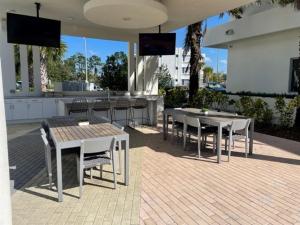 a patio with two tables and chairs and a bar at Stylish Modern 3bd-2ba With Amenities in Daytona Beach