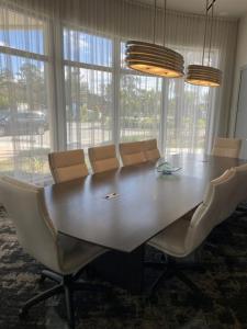una mesa de comedor con sillas alrededor y ventanas en Stylish Modern 3bd-2ba With Amenities en Daytona Beach
