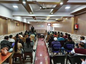 un grupo de personas sentadas en sillas en una sala de conferencias en Paradise Home stay en Rāni Pokhri