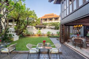 a patio with a table and chairs and a yard at Puripunn Hideaway in Chiang Mai